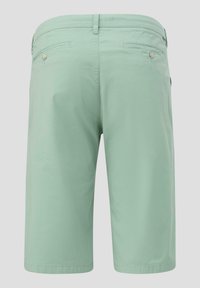 Shorts en coton vert clair avec une taille plate, deux poches arrière et deux poches latérales ; texture lisse et coupe au niveau du genou.