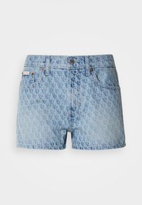 Lys blå denimshorts med et teksturert, gjentakende mønster. Har knappelukking og rød merkeetikett på venstre lomme.