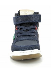 Baskets montantes pour enfants en bleu marine avec paillettes. Elles possèdent une sangle Velcro, des lacets, des accents en cuir et une semelle en caoutchouc.