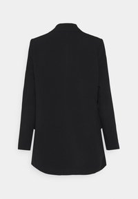 Blazer noir à manches longues, cintré, avec un dos droit, un col et un ourlet légèrement arrondi sur un fond clair uni.