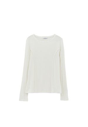 Langsleeve wit bovenstuk van zachte stof met gebogen zijnaad en een ronde halslijn, met een relaxte pasvorm en een soepele textuur.