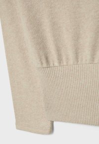 Beige pullover sweater made of soft fabric, featuring a ribbed cuff and hem. The texture is smooth with a subtle heathered pattern.