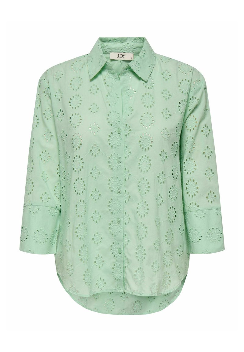 Light green blouse with a button-down front, three-quarter sleeves, and floral eyelet patterns throughout. Soft, textured cotton fabric.