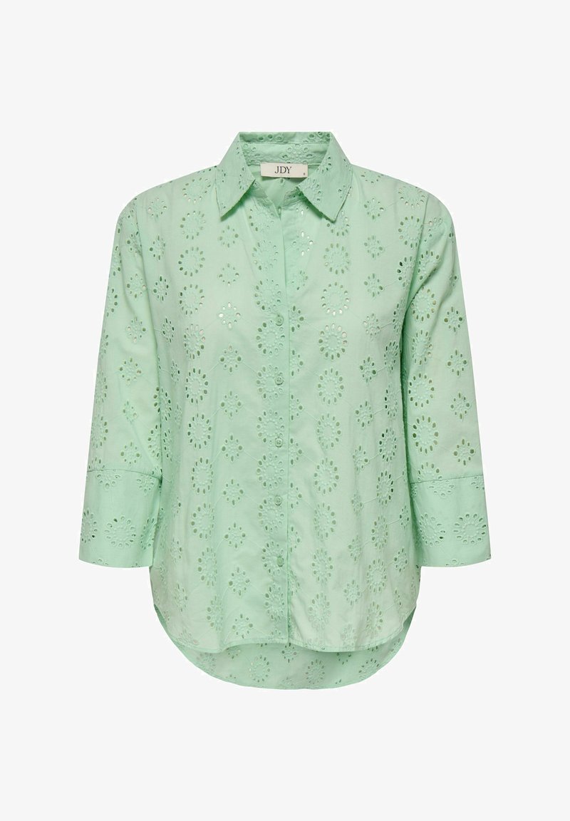 Light green blouse with a button-down front, three-quarter sleeves, and floral eyelet patterns throughout. Soft, textured cotton fabric.