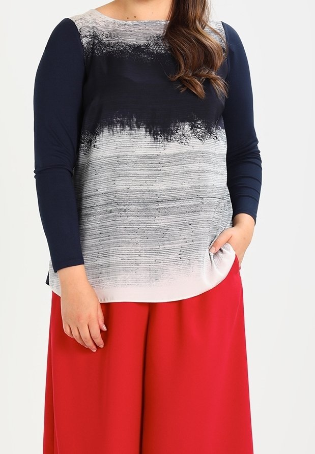 Kolmveerandi varrukatega topp, millel on tumesinised varrukad ja halli ning valge tooni gradient kehapiirkond; omab abstraktset tekstuuri ja kaardus alläär.