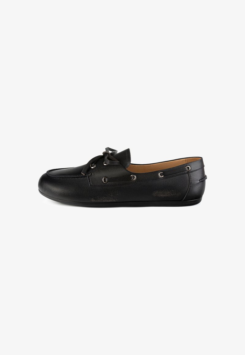 Mocassin en cuir noir avec design moc toe, nœud en lacet sur le dessus, œillets métalliques et semelle plate basse, vu de l’extérieur sur fond blanc.