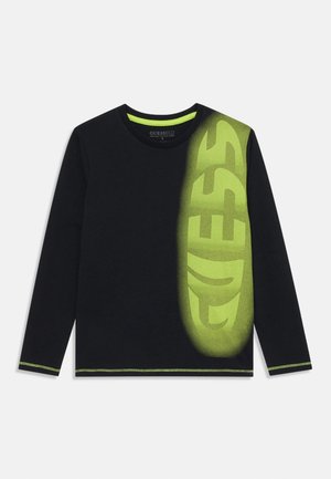 Sort langærmet skjorte med neon-grøn "GUESS" tekst lodret på højre side, neon-grøn kraveforing og matchende syninger.