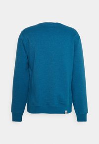 Felpa di cotone blu con scollatura a girocollo, maniche lunghe, polsini e fascia inferiore a coste. Design minimalista, senza grafiche o decorazioni aggiuntive.