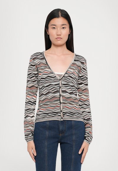 Striped cardigan with a V-neck, black, white, and pastel wave patterns. Features long sleeves and black buttons along the front.