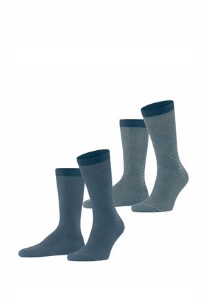 Drei Paar Socken in verschiedenen Blautönen. Ein Paar ist einfarbig, während die anderen dünne Streifen haben. Strickstoff mit gerippten Bündchen.