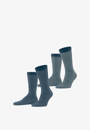 Trois paires de chaussettes dans des nuances de bleu. Une paire est unie, tandis que les autres présentent de fines rayures. Tissu tricoté avec des bords côtelés.