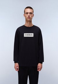 Long-sleeve black t-shirt made of cotton. Features a white rectangular logo on the chest that reads "NAPAPIJRI geographic." Smooth texture.