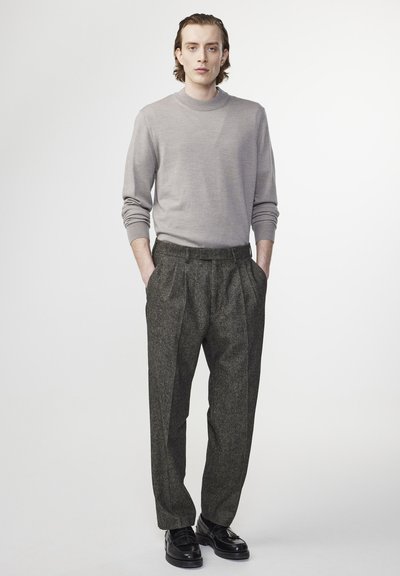 Light gray sweater with a high neckline, paired with dark plaid trousers. Black shoes complete the outfit. Smooth texture and tailored fit.