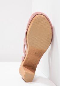 Rosa Wildleder Schuh mit dickem Holzabsatz und strukturiertem Gummisohle, ausgestattet mit einem Riemen und offener Zehenpartie.