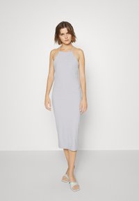 Vestido midi halter em cinza claro com um corte ajustado, combinado com mules abertas em cinza claro com design de bico quadrado.