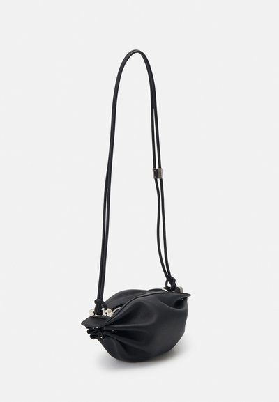 Petit sac bandoulière en cuir noir avec côtés froncés, quincaillerie argentée, fermeture éclair et fine bandoulière ajustable.