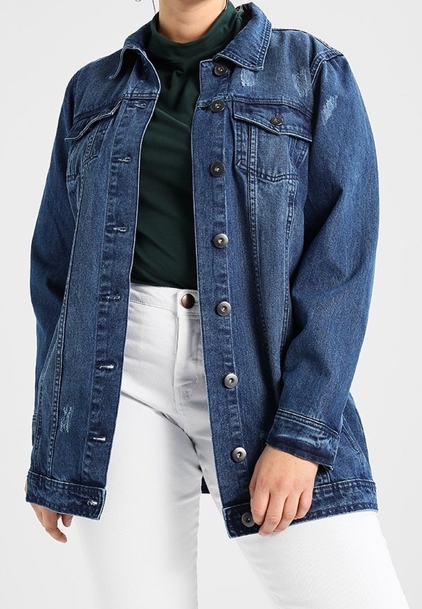 Jeansjacka, mörkblå, med en knapp-up front, två bröstfickor, lätt slitage och en avslappnad passform. Bärs över en grön topp.