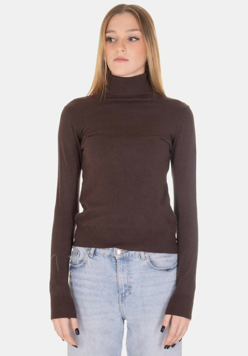 Maglione marrone a collo alto in tessuto a costine, design aderente con maniche lunghe, abbinato a jeans a vita alta di colore azzurro chiaro.