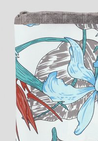 Tekstylia w kwiatowy wzór z niebieskimi kwiatami, zielonymi łodygami i czerwonymi liśćmi na jasnym tle z szarymi akcentami.