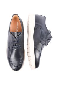 Scarpe in pelle di un blu navy scuro con una finitura liscia, design con lacci e una suola in gomma chiara con un motivo di battistrada testurizzato.
