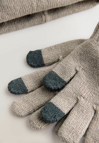 Pelēkas adītas cimdi ar tumši pelēkām pirkstu galiem, ar teksturētu virsmu un noapaļotu formu. Mīksts, silts dizains aukstam laikam.