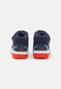 Navy high-top sneakers with red accents, featuring a soft textile upper, Velcro strap, padded collar, and contrasting white sole.