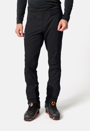 Pantaloni softshell neri con vestibilità slim, dotati di due tasche frontali, rinforzi nella parte inferiore delle gambe e zip alle caviglie, progettati per attività all'aperto.