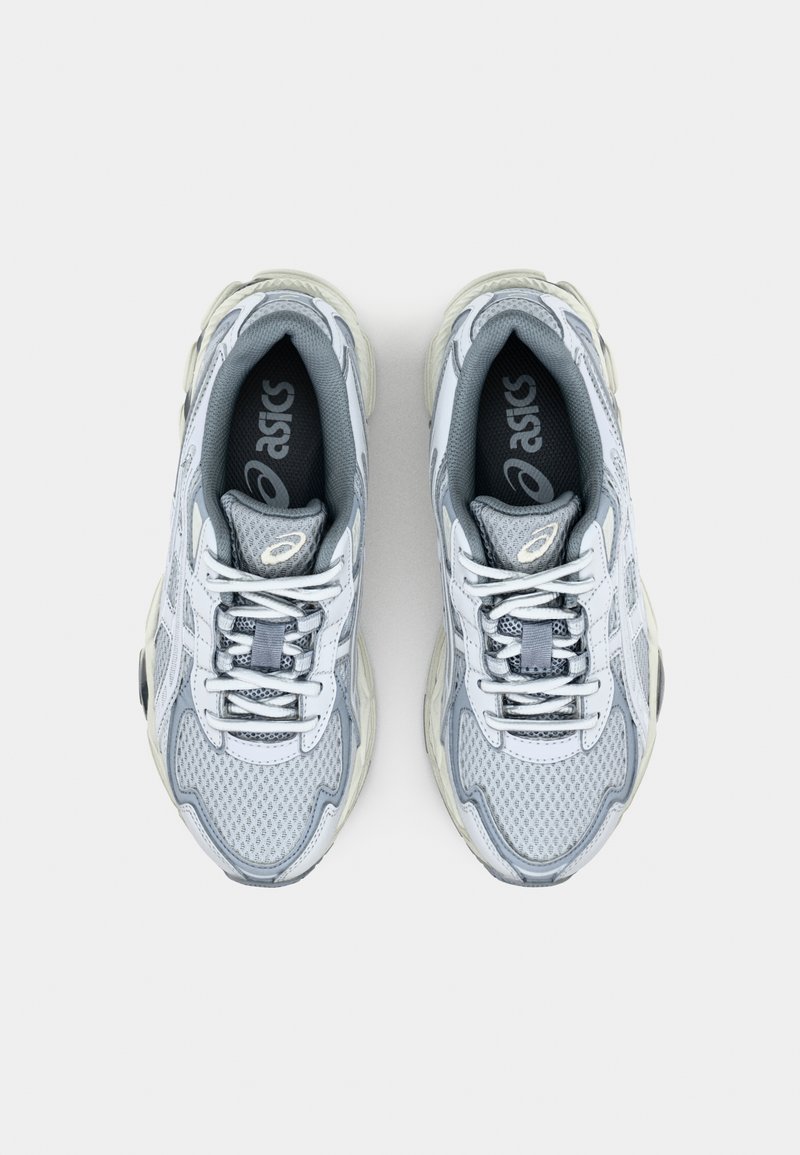 Graue Sportschuhe mit mesh-Obermaterial, abgerundetem Zehenbereich, Schnürsenkeln und gepolstertem Kragen. Mit Branding auf der Zunge und seitlichen Akzenten. Strukturierten Sohlen für Traktion.