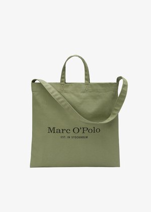 Sac tote en toile vert avec deux poignées courtes et une longue bandoulière. Présente un texte noir indiquant "Marc O'Polo EST. À STOCKHOLM."