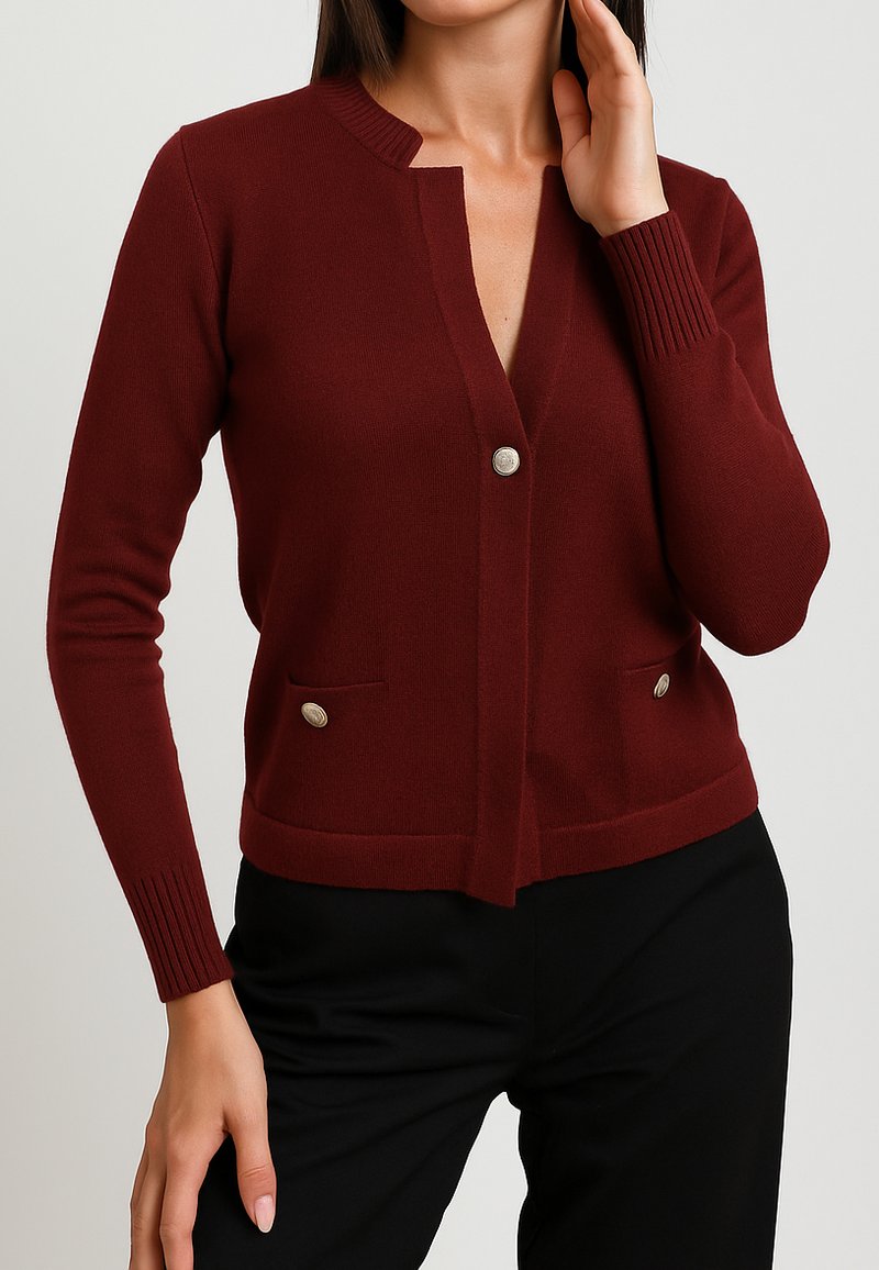 Cardigan bordeaux con scollatura a V, polsini a coste e due tasche anteriori. Presenta bottoni in tonalità argentata e un design aderente. Materiale in maglia morbida.