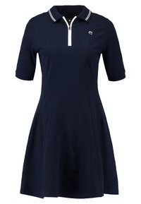 Granatowa sukienka polo z krótkim rękawem, z zamkiem przy szyi, białymi paskami na kołnierzyku oraz rozkloszowanym fasonem, wykonana z gładkiego, elastycznego materiału.