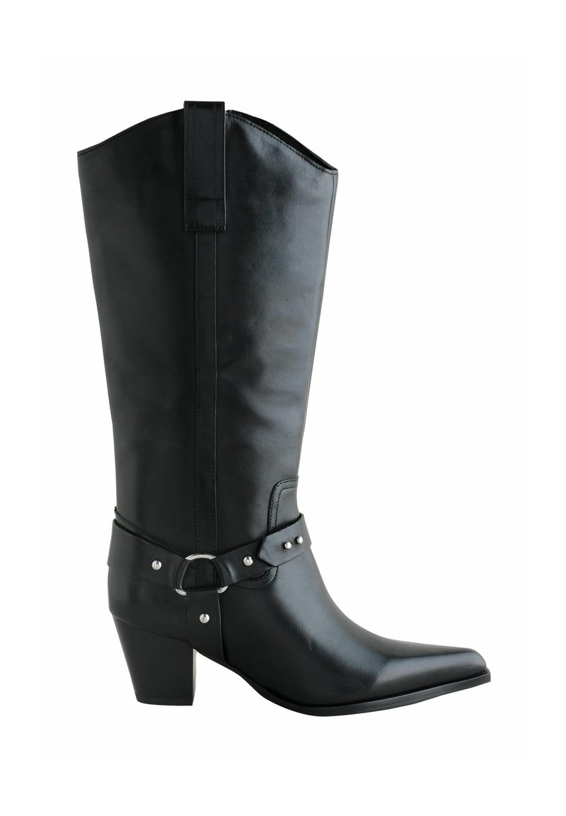 Bota de cowboy de cuero negro con punta afilada, tacón de altura media y una correa decorativa con una hebilla circular y tachuelas.