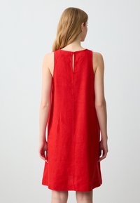 Rotes Leinen, ärmelloses Kleid mit relaxter Passform, rundem Ausschnitt und einem kleinen Schlüssellochdetail auf der Rückseite. Glatte Textur.