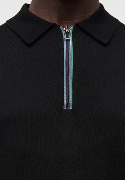 Μαύρο πόλο μπλουζάκι με φερμουάρ και όρθιο γιακά, διακοσμημένο με πολύχρωμες ρίγες στο φερμουάρ, κατασκευασμένο από υλικό πλεκτής υφής.