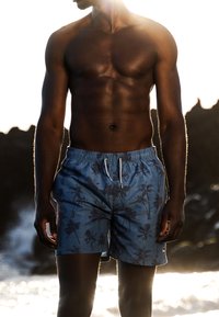 Blauwe zwemshorts met een palmbomenpatroon, elastische tailleband en koord. Lichtgewicht stof met een gladde textuur.