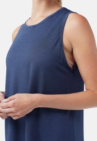 T-shirt de sport sans manches bleu marine avec un motif texturé, encolure ronde et coupe décontractée ; le tissu semble respirant et léger.