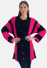 Brede gebreide cardigan met gedurfde roze en zwarte strepen, oversized mouwen en een knoopsluiting aan de voorkant. Gelaagd materiaal met een ontspannen pasvorm.