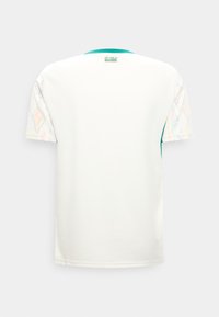 Maillot de sport blanc avec col bleu sarcelle, manches à motifs subtils et inscription « Les Lions du Sénégal » en haut du dos.