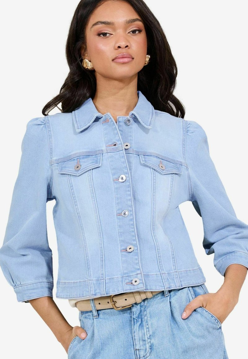 Giacca di jeans azzurro chiaro con un design strutturato, dotata di colletto, tasche anteriori e chiusure a bottoni; leggera e con una consistenza morbida.