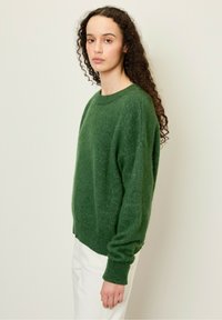 Pullover verde a maglia con scollo rotondo, maniche lunghe e vestibilità comoda. La texture appare morbida con una finitura leggermente spazzolata.