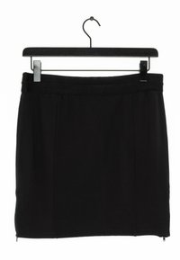 Falda negra ajustada de tela suave, con una cinturilla texturizada y detalle de cremallera lateral, exhibida en un gancho negro.