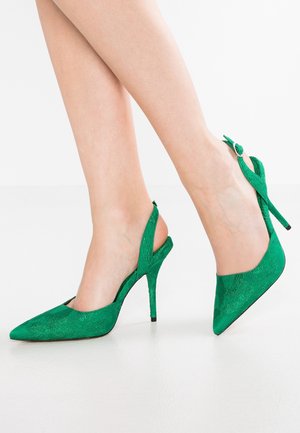 Souliers à talons aiguilles verts avec un bout pointu, tissu texturé, talon stiletto de 10 cm et une sangle avec boucle à l'arrière de la cheville.