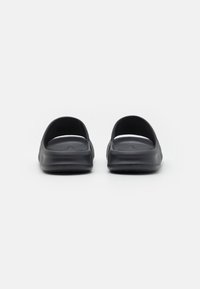 Sorte vandtætte slip-on sko med en afrundet form, åben hæl-design og tekstureret indersål. Letvægtsmateriale, fleksible såler.