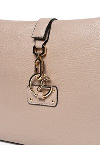 Bolso de mano de cuero beige con un acabado texturizado, que presenta un detalle de hardware en tono dorado y un logo prominente en el cierre.