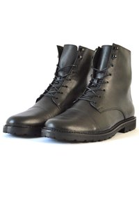Botas de cuero negro hasta el tobillo con un acabado liso, punteras redondas, diseño de cordones y ojetes de metal, que cuentan con una suela de goma texturizada.