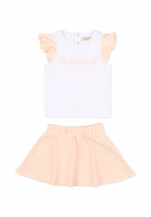 Top bianco senza maniche con maniche arricciate color pesca e scritta "trussardi", abbinato a una gonna elasticizzata in tinta pesca per bambini.