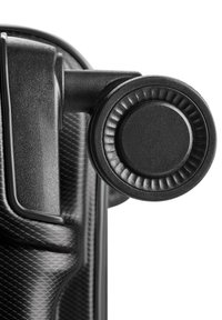 Roue noire de valise avec surface texturée et support fixé sur fond blanc.