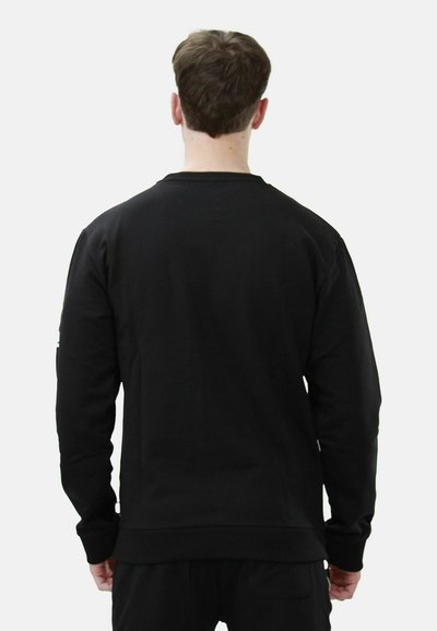 Felpa nera realizzata in un tessuto morbido, con maniche lunghe, scollatura rotonda e polsini e orlo a costine per una vestibilità aderente.