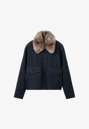 Tumma denimtakki tekoturkiskauluksella, jossa kaksi rintataskua ja vetoketjukiinnitys. Karkea, rento malli.