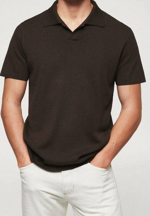 Polo à manches courtes de couleur brun foncé avec col, en tissu texturé. Présente un col en V subtil et est associé à un pantalon de couleur claire.